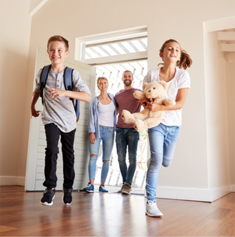 A happy family and child running towards their new house symbolising a successful residential mortgage completion in rugby