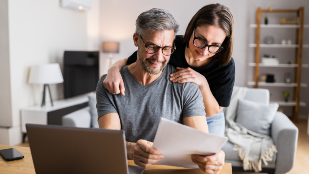 A happy couple looking at property options, representing the financial confidence gained through our expert mortgage advice in Rugby.